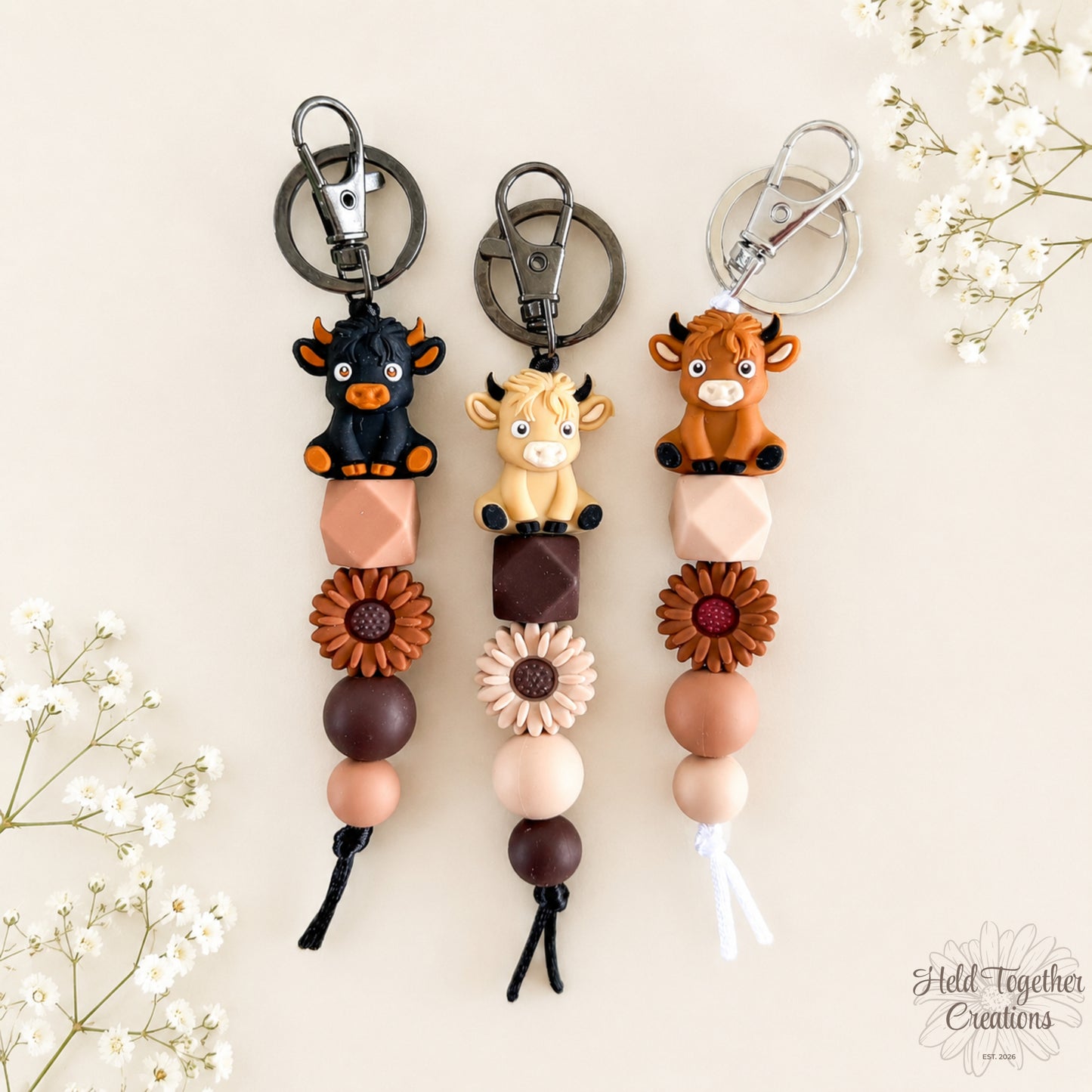 Handmade Little Moo silicone bead keyrings with cow characters, daisy beads and neutral silicone beads.