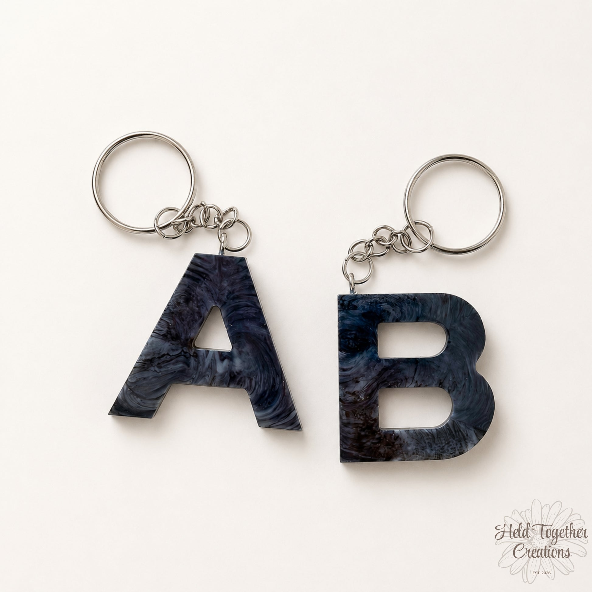 Two keychains with marbled 'A' and 'B' letters on a white background.
