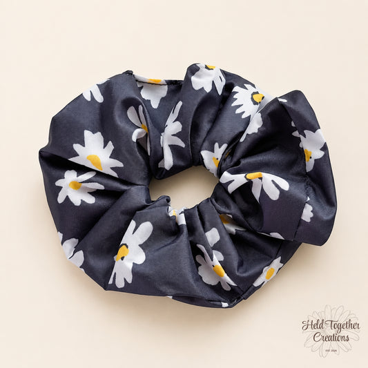 Moonlit Daisy Scrunchie with black fabric and white daisy floral print, handmade by Held Together Creations.