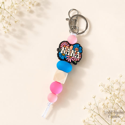Handmade Nana silicone bead keyring with pink, blue and cream beads, floral Nana charm and silver keyring hardware.