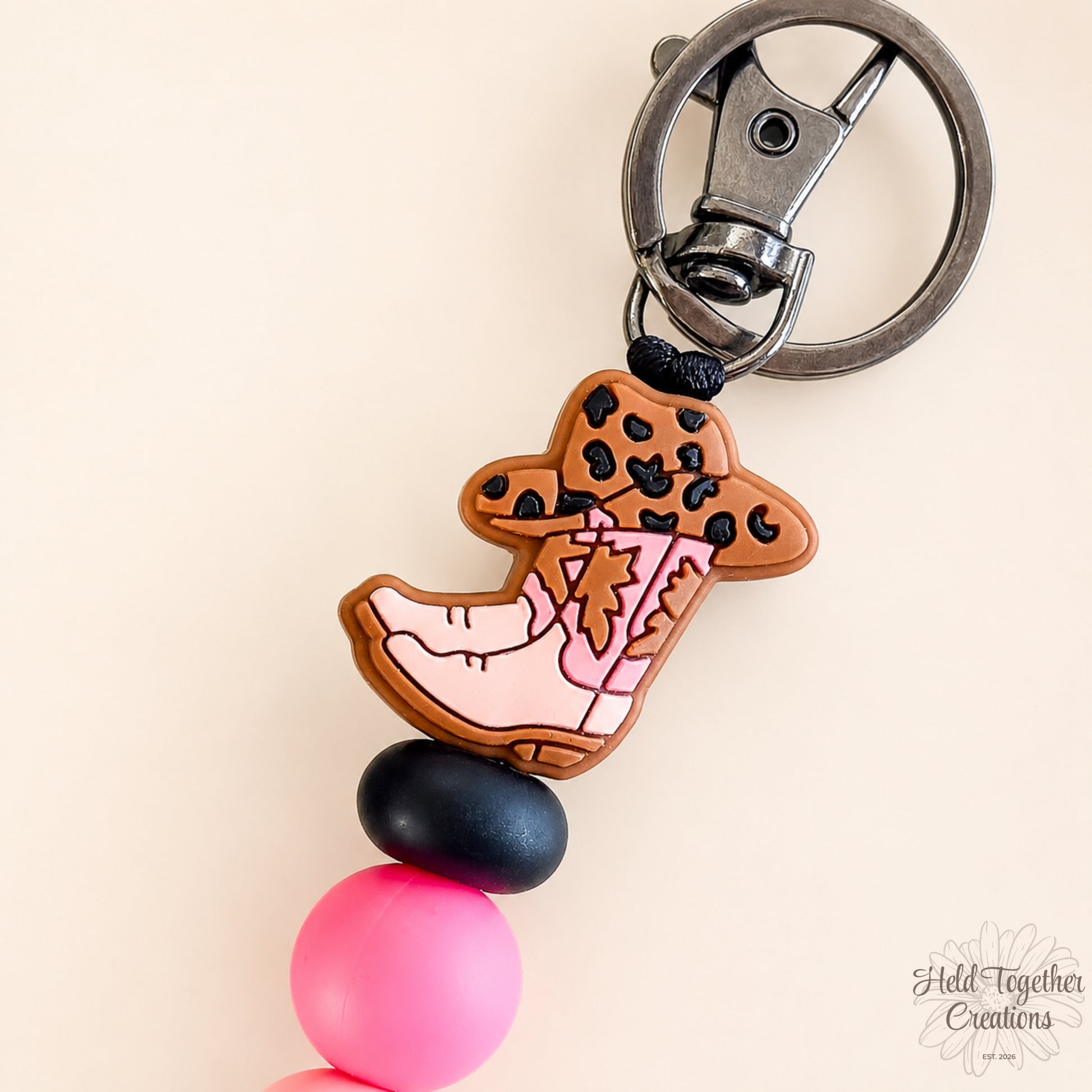 Handmade cowgirl boot silicone bead keyring with pink and black beads, metal keyring hardware and western boot charm.