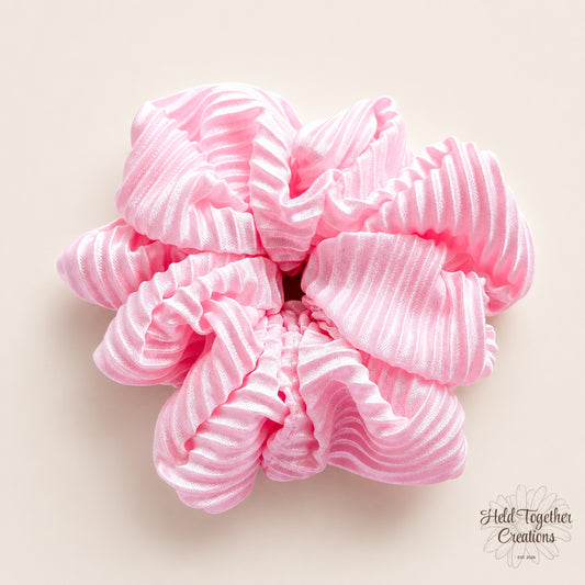 Pink Fizz handmade scrunchie in bright pink textured satin-style fabric on a soft neutral background.