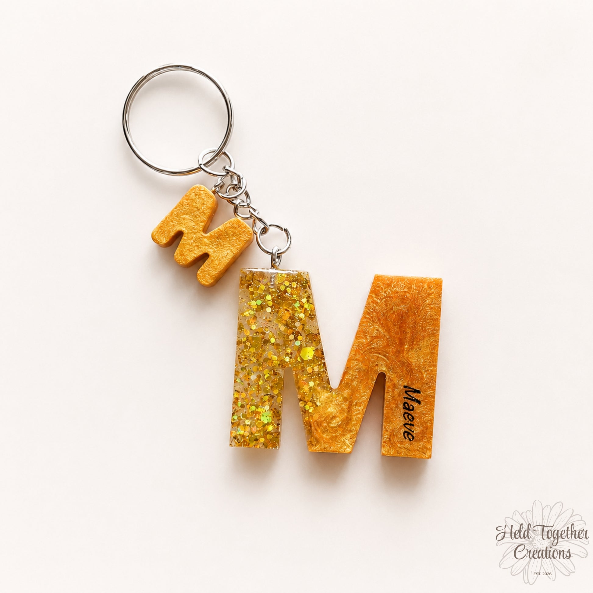 Keychain with glittery 'M' letter on a white background