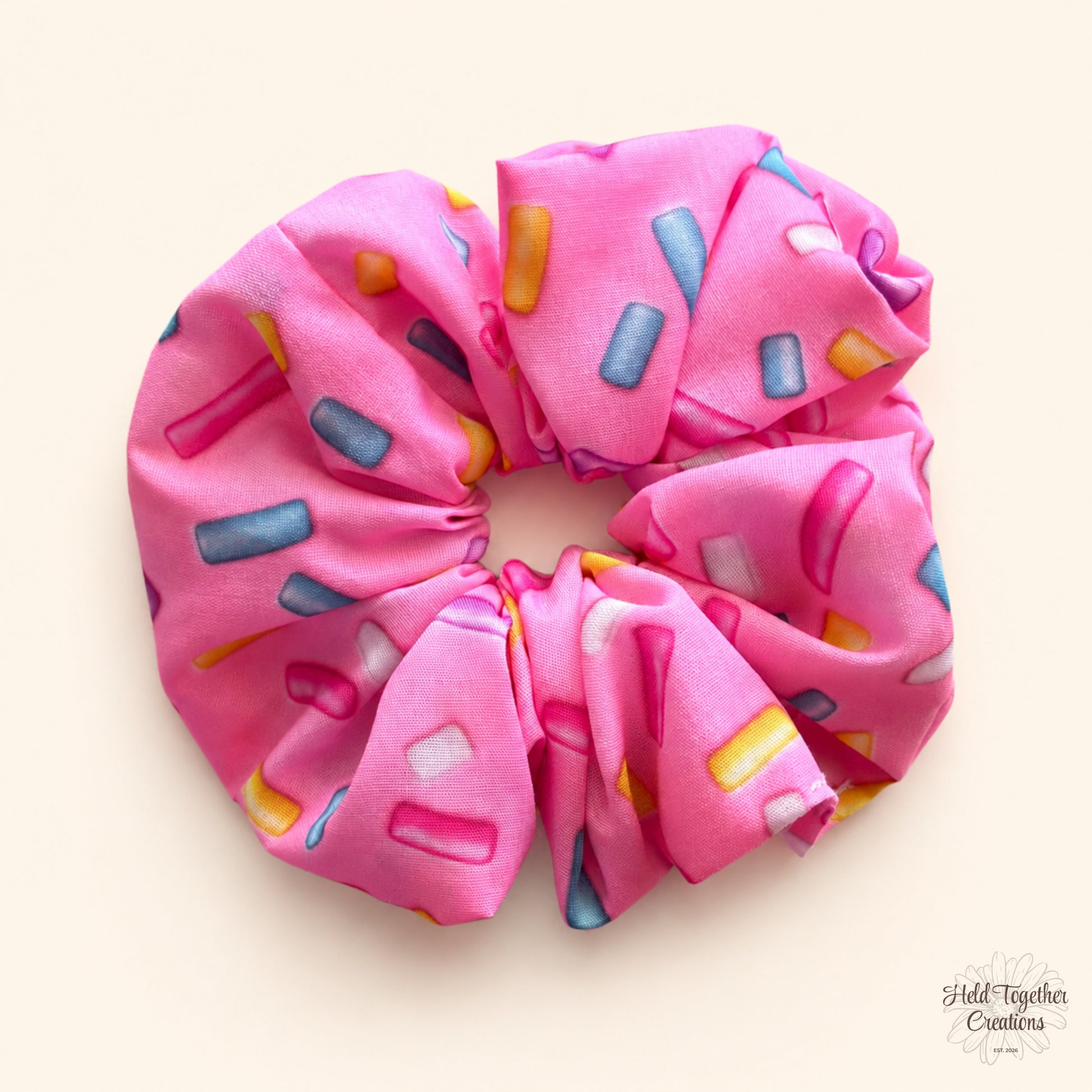 Pink Sprinkle Scrunchie flat lay on a warm ivory background with colourful sprinkle-style pattern.