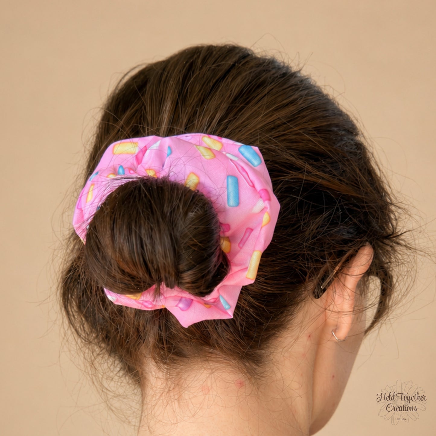 Pink Sprinkle Scrunchie worn in a bun, showing colourful sprinkle print on pink fabric.