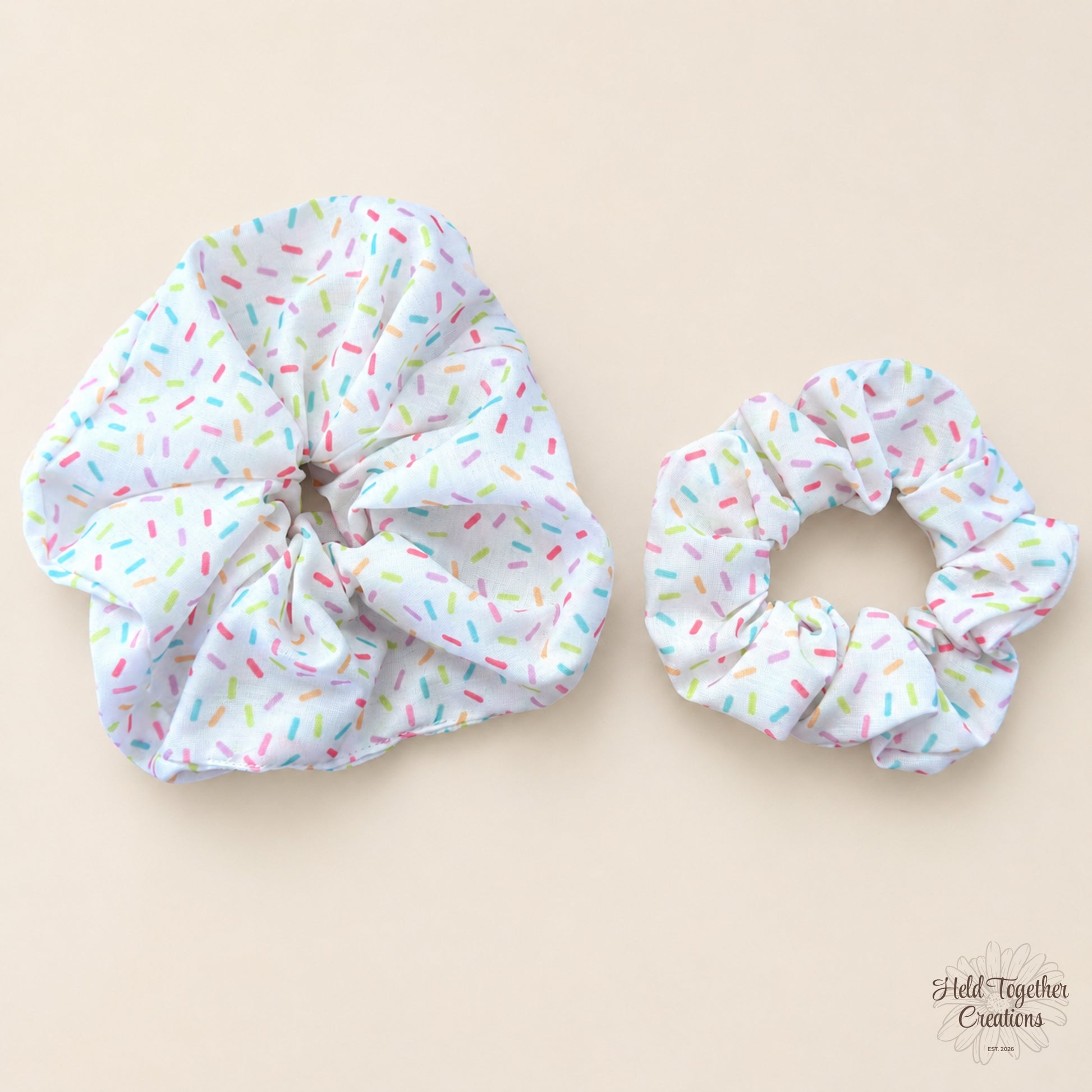 Small and large Rainbow Sprinkle Scrunchies side by side on warm neutral background