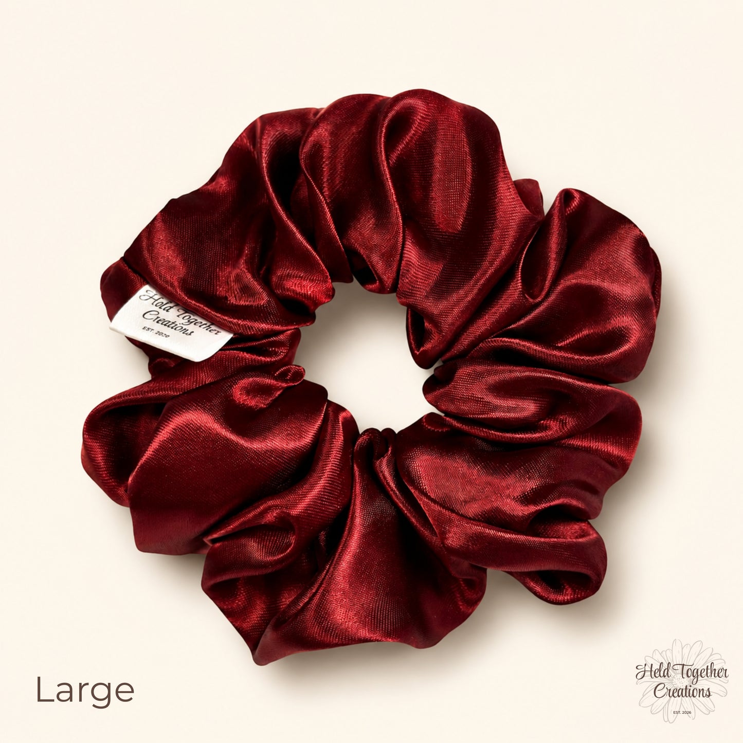 Large ruby satin scrunchie on a warm ivory background