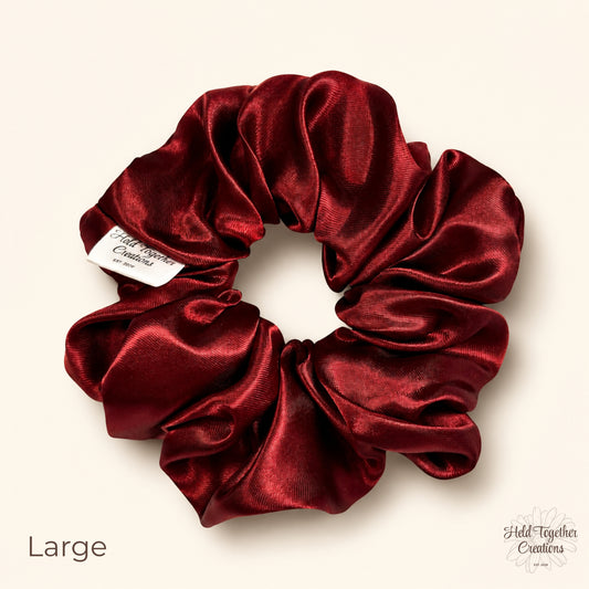 Large ruby satin scrunchie on a warm ivory background