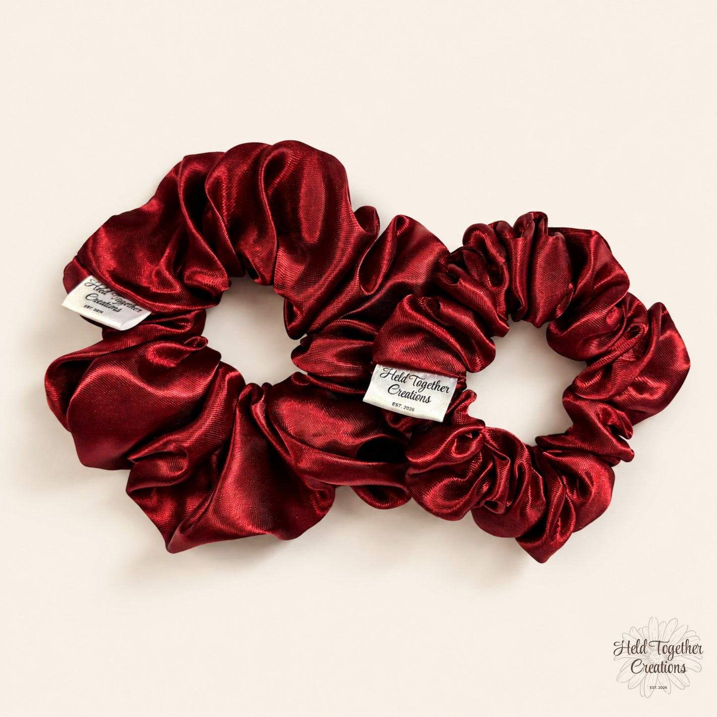 Small and large ruby satin scrunchies displayed together
