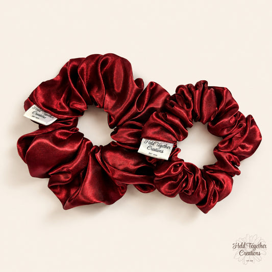 Small and large ruby satin scrunchies displayed together