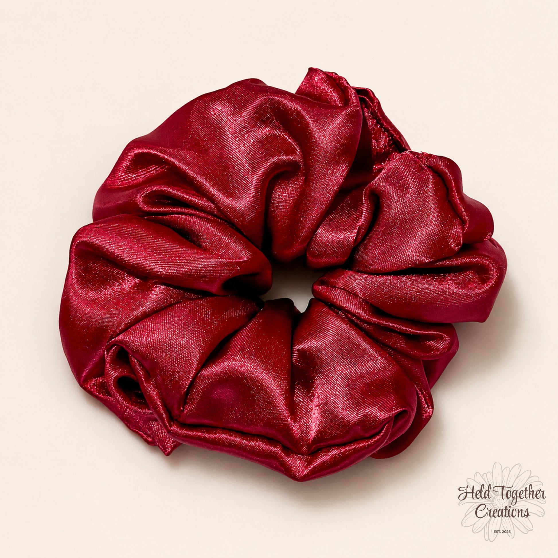 Ruby red satin scrunchie with a glossy finish, handmade by Held Together Creations.