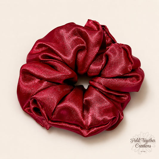 Ruby red satin scrunchie with a glossy finish, handmade by Held Together Creations.
