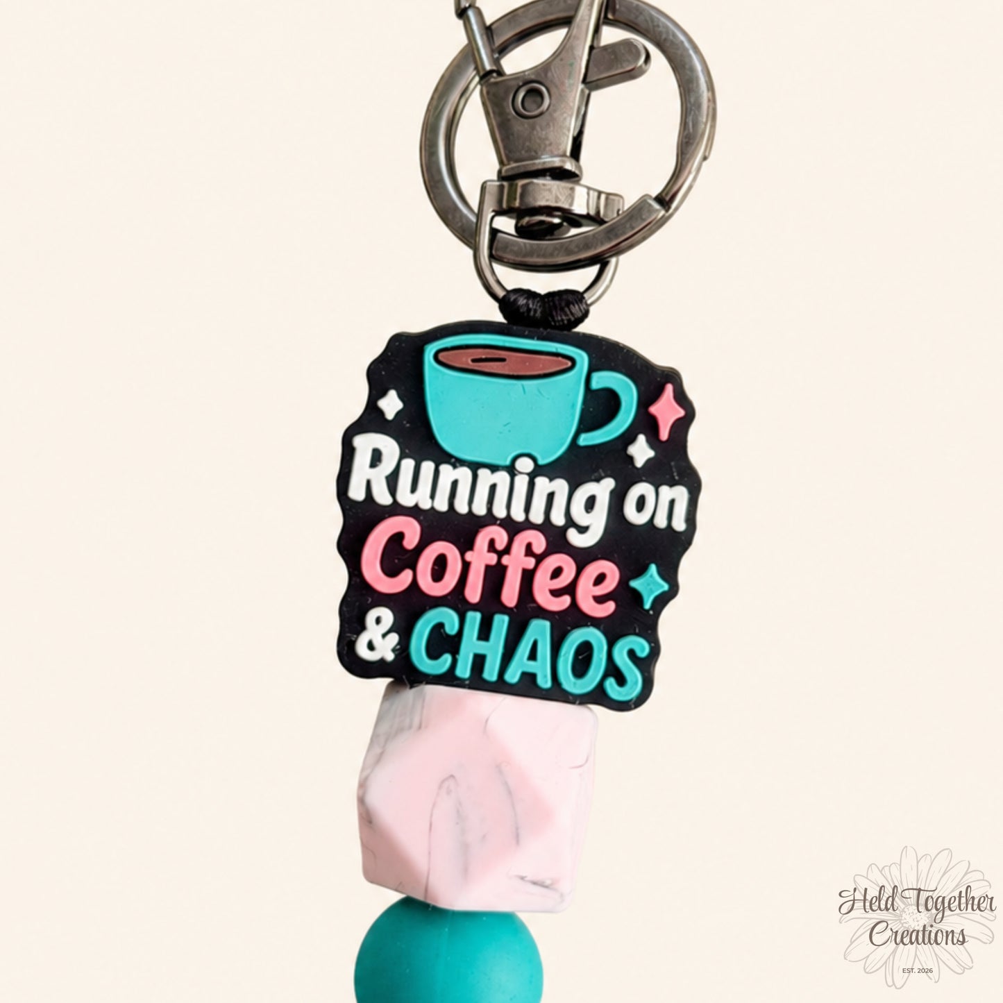 Handmade Running on Coffee and Chaos silicone bead keyring with teal, pink and marble-style beads on a warm ivory background.