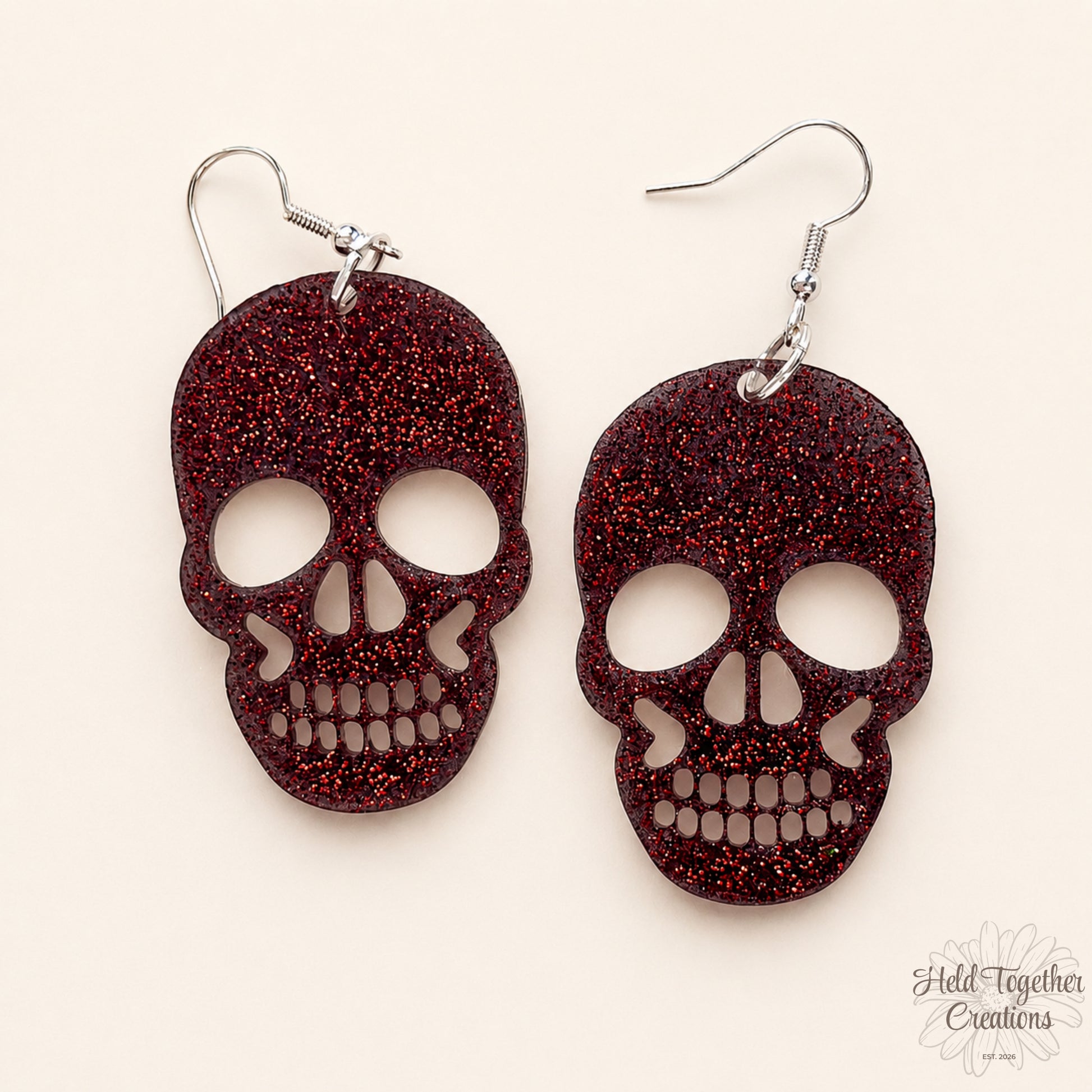 Red glittery skull-shaped earrings on a white background