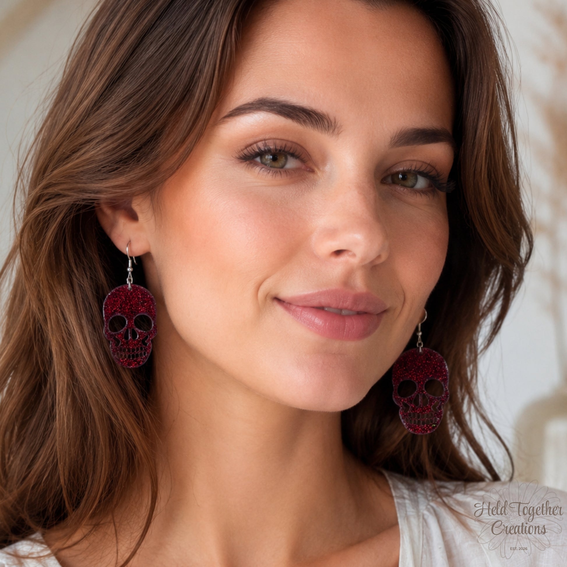 Woman wearing red skull earrings with a neutral background