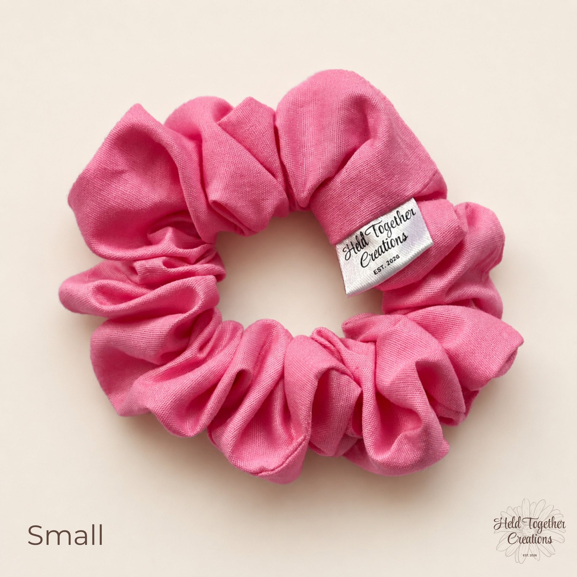 Small pink cotton scrunchie with gathered cotton fabric and brand tag