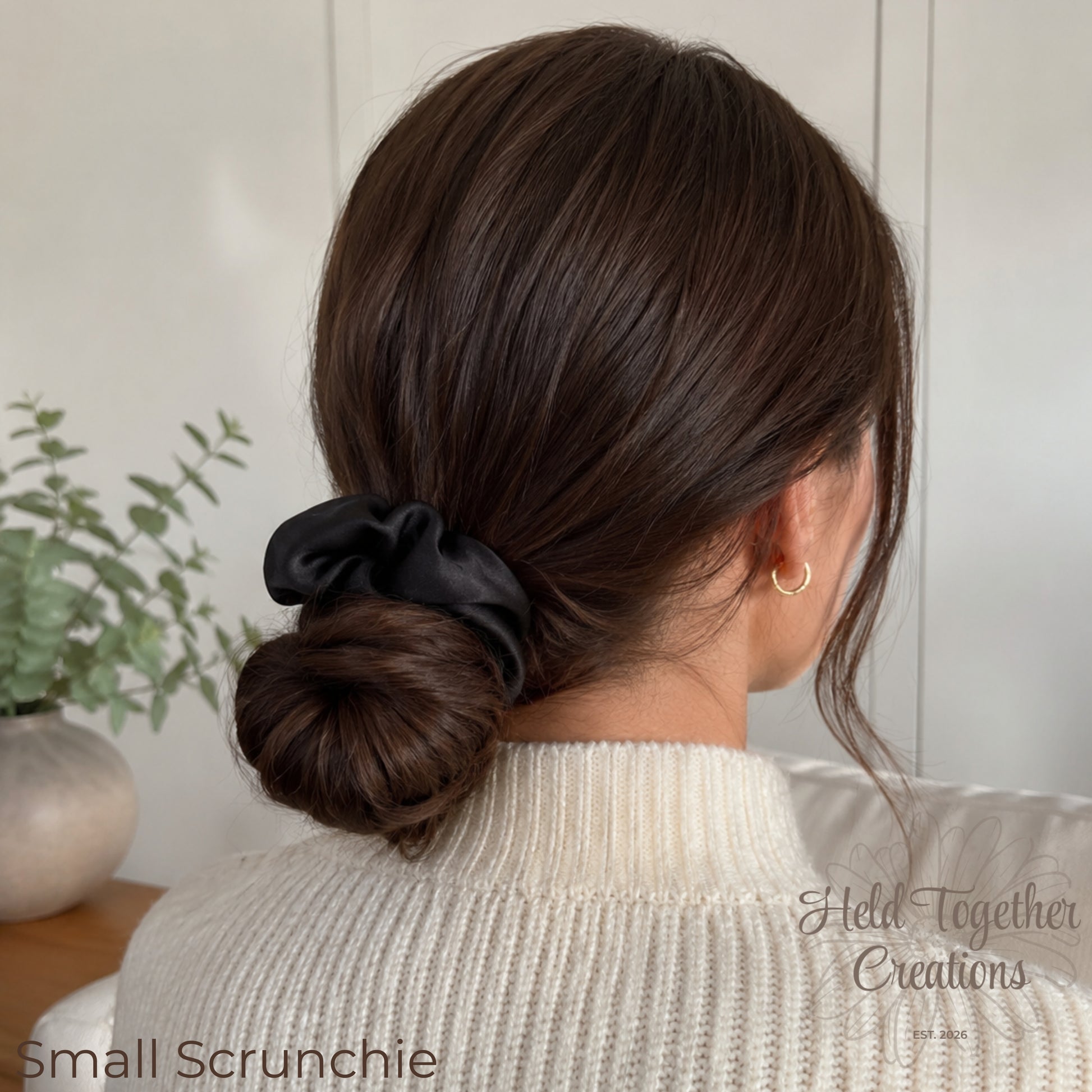 Black satin handmade scrunchies in large and small sizes on a soft neutral background.
