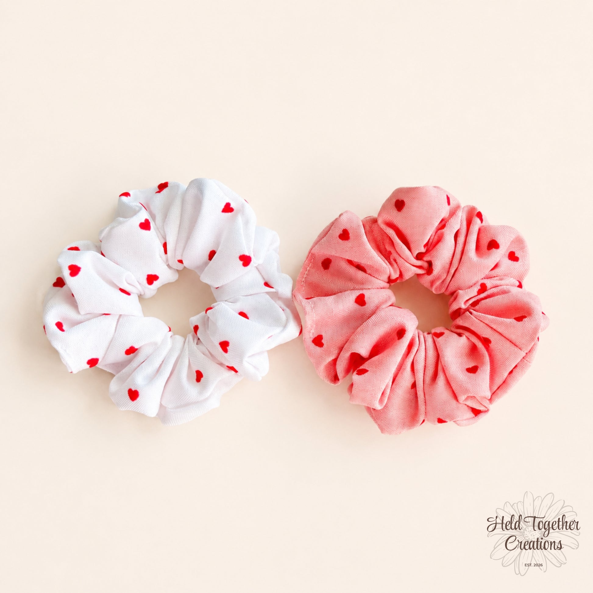 White and coral velvet-style heart scrunchies with red heart print photographed together on a warm ivory background.